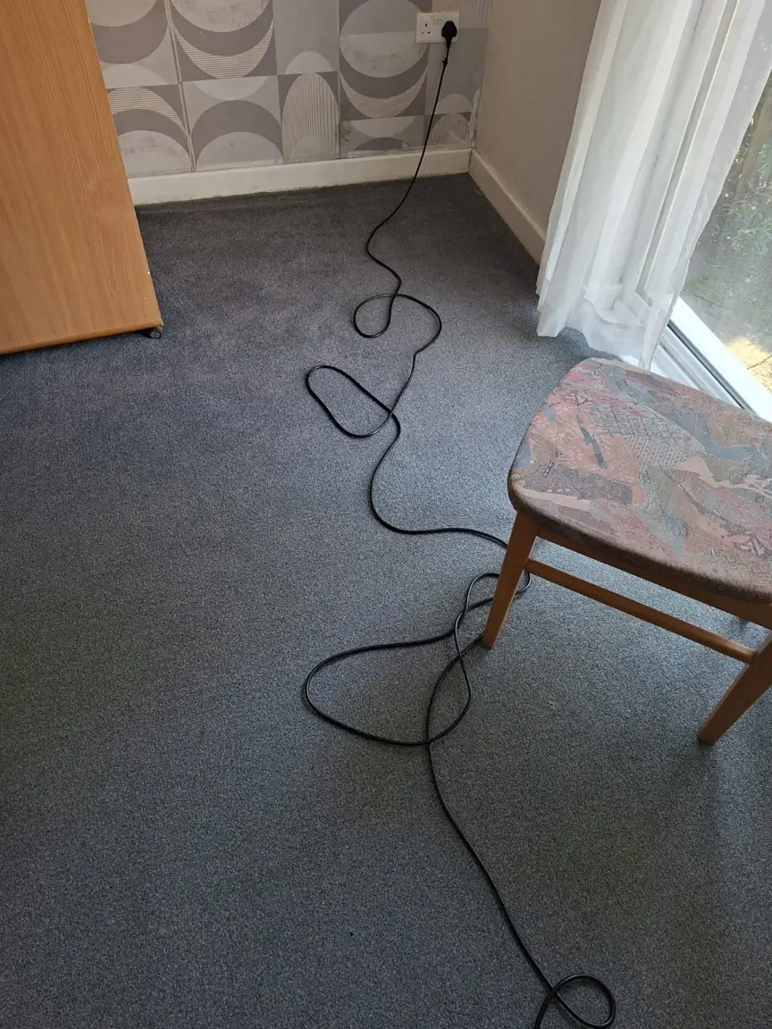 Grey carpet beside a chair and glazed door during the four-room carpet clean